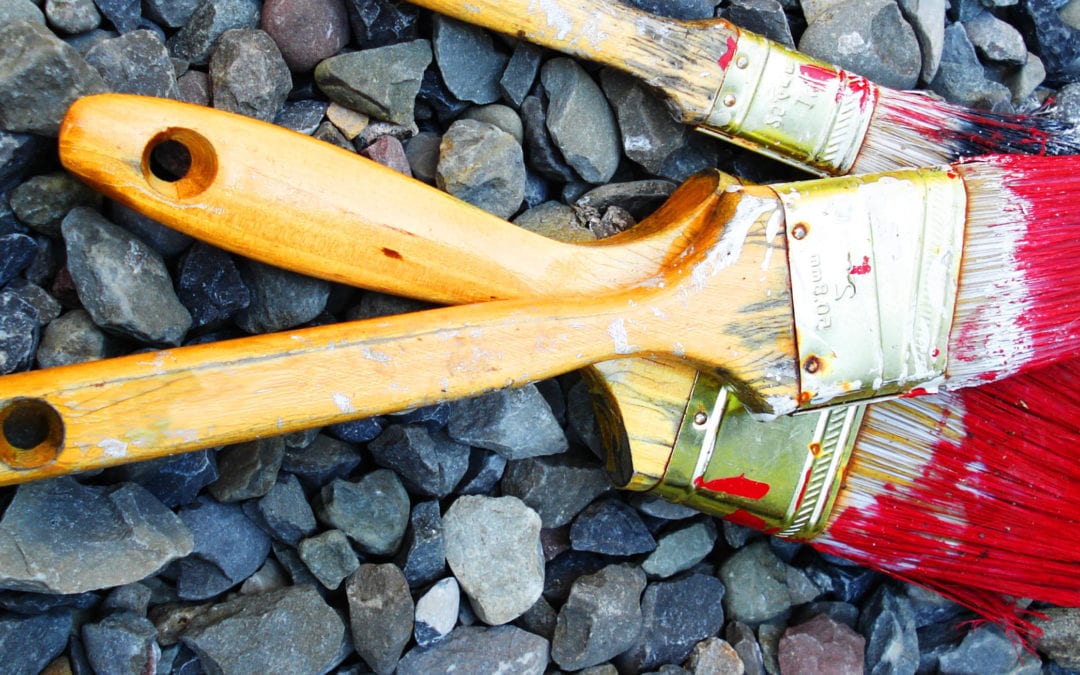 three paint brushes with red paint on them