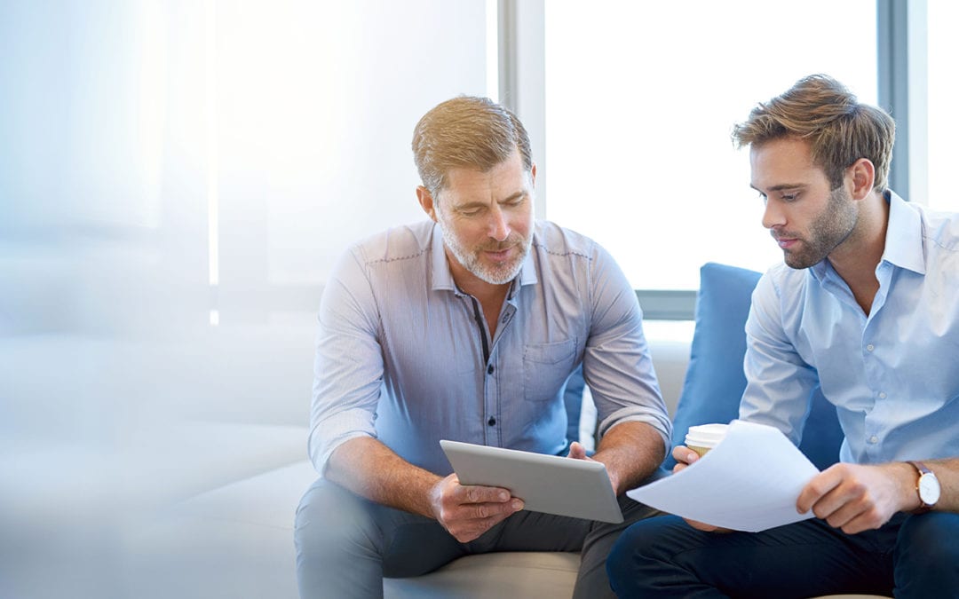 two businessmen discussing something displayed on an ipad