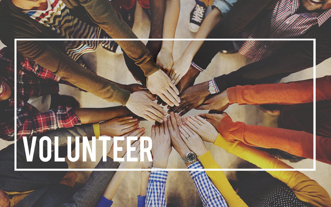 a group with their hands in a circle with the word "Volunteer" on it