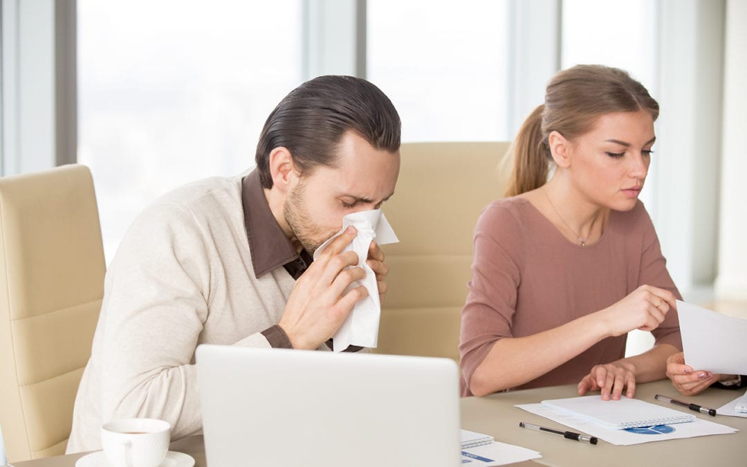 a man sneezing sitting next to his partner