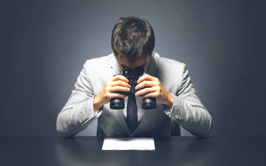 a businessman looking at a contract with binoculars