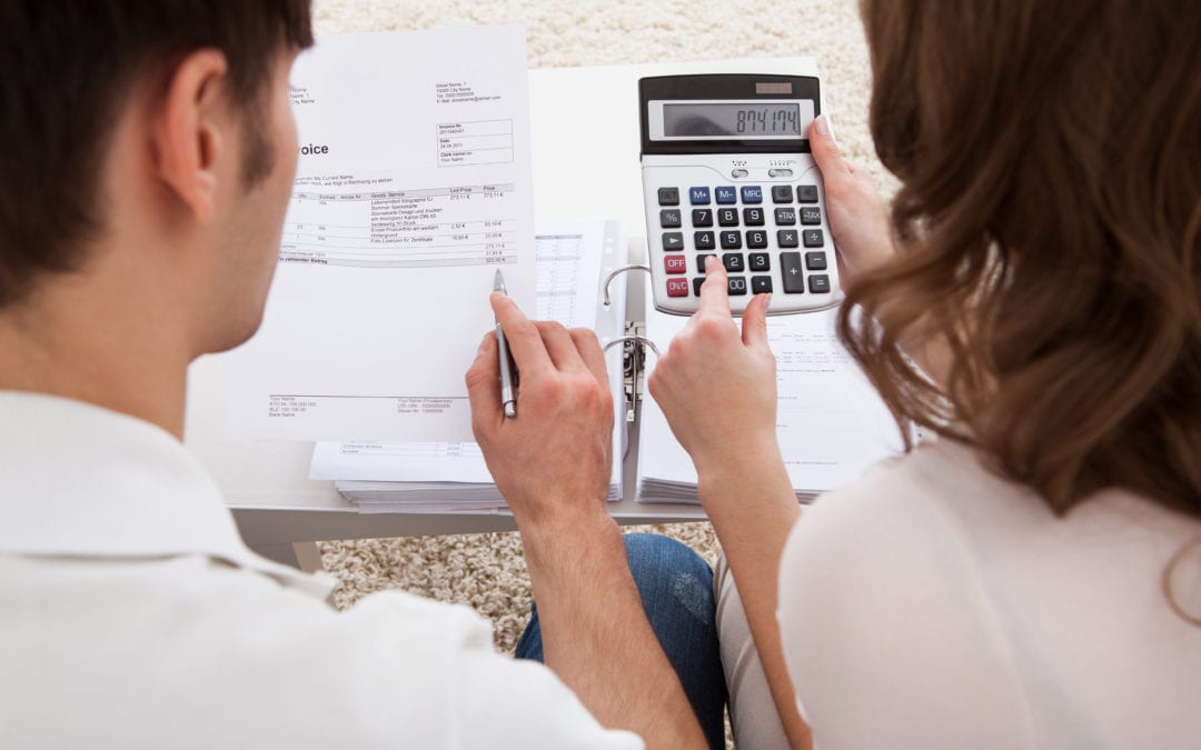 a couple reviewing an invoice with a calculator